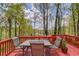 An outdoor deck features a table set and chairs with a scenic view of the surrounding trees at 725 Martin Field Dr, Lawrenceville, GA 30045
