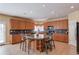 Eat-in kitchen with island and seating, lots of wood cabinets, tile floors, and black appliances at 725 Martin Field Dr, Lawrenceville, GA 30045