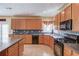 Spacious kitchen with black appliances, tile floors, and wooden cabinets at 725 Martin Field Dr, Lawrenceville, GA 30045
