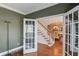 Cozy office showcasing neutral paint and charming trim with open french doors leading to the dining area at 725 Martin Field Dr, Lawrenceville, GA 30045