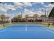 Well-maintained blue and green tennis court with netting surrounded by a black chain link fence at 725 Martin Field Dr, Lawrenceville, GA 30045