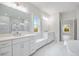 This bathroom has white marble tile, dual vanities, and a standalone tub at 1010 Coleman Place Dr, Roswell, GA 30075