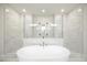 Bright bathroom features a soaking tub and glass enclosed shower with marble tile at 1010 Coleman Place Dr, Roswell, GA 30075