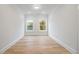 Empty bedroom boasting hardwood floors, white trim, and two windows that offer natural light at 1010 Coleman Place Dr, Roswell, GA 30075