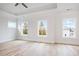 This bedroom features three big windows, hardwood floors, and a ceiling fan at 1010 Coleman Place Dr, Roswell, GA 30075