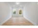 Bright bedroom featuring hardwood floors, two large windows, and white trim at 1010 Coleman Place Dr, Roswell, GA 30075