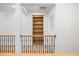 Upstairs hallway with hardwood floors, built-in bookcase, and wood and metal railing at 1010 Coleman Place Dr, Roswell, GA 30075