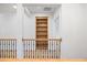 Second-floor hallway with custom-built bookcase and wood and iron railings at 1010 Coleman Place Dr, Roswell, GA 30075