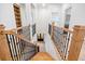 Hallway showcasing hardwood stairs and railing, leading towards a black door and kitchen area at 1010 Coleman Place Dr, Roswell, GA 30075