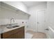 Convenient laundry room with granite countertop, stainless sink, and tile flooring at 1010 Coleman Place Dr, Roswell, GA 30075