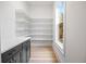 Walk-in pantry featuring custom shelving, counter space, and natural light from a window at 1010 Coleman Place Dr, Roswell, GA 30075