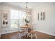 Sunlit dining area with hardwood floors, modern lighting, and a view of the backyard at 204 Phillips Ln, Alpharetta, GA 30009