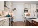 Modern kitchen features white cabinets, stainless steel appliances, and a tile backsplash at 204 Phillips Ln, Alpharetta, GA 30009