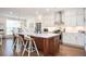 Bright kitchen features white cabinets, stainless steel appliances, and a large island with seating at 204 Phillips Ln, Alpharetta, GA 30009