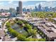 An aerial view of a community showcasing a picturesque pond, lush trees, and a stunning cityscape backdrop at 400 17Th Nw St # 2029, Atlanta, GA 30363
