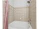 Neutral-tiled bathtub with showerhead and pink curtain for a relaxing bathing experience at 400 17Th Nw St # 2029, Atlanta, GA 30363