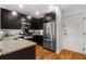 Modern kitchen featuring stainless steel appliances, dark cabinets, and a granite countertop at 201 W Ponce De Leon Ave # 303, Decatur, GA 30030