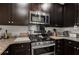 Close up of a modern kitchen with stainless steel appliances and dark wooden cabinets at 201 W Ponce De Leon Ave # 303, Decatur, GA 30030