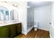 Modern bathroom featuring dual sinks, bronze fixtures, a glass-enclosed shower, and wood flooring at 2010 Bixby Se St, Atlanta, GA 30317