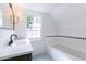 Bright bathroom featuring a tub, white vanity and black faucet at 2010 Bixby Se St, Atlanta, GA 30317