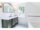 Well-lit bathroom with decorative mirror, vanity and combination bath and shower at 2010 Bixby Se St, Atlanta, GA 30317