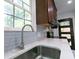 Close-up of kitchen sink area with chrome faucet and stylish backsplash under a bright window at 2010 Bixby Se St, Atlanta, GA 30317