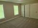 Neutral carpeted bedroom with two windows and a double-door closet at 1234 Pinedale Nw Cir, Conyers, GA 30012