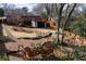 Lush backyard featuring a deck, stone accents, mature trees, and a charming play area at 1721 Hudson Woods Trl, Decatur, GA 30033
