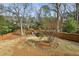 Fenced backyard with mature trees, a playset, and landscaped areas, perfect for outdoor activities at 1721 Hudson Woods Trl, Decatur, GA 30033