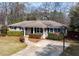 Inviting single-story home with a well-manicured lawn and mature shrubbery accentuating the exterior at 1721 Hudson Woods Trl, Decatur, GA 30033