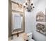 Elegant bathroom featuring a decorative mirror, chandelier, and artistic tree painting, providing a unique and stylish space at 2358 New Salem Trce, Marietta, GA 30064