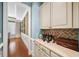 Butler's pantry with wine storage, custom cabinetry, and a brick backsplash, blending functionality and style at 2358 New Salem Trce, Marietta, GA 30064
