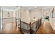 Upstairs hallway with wood floors, decorative railings and lighting, connecting the home's living spaces with style at 2358 New Salem Trce, Marietta, GA 30064