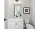 Compact bathroom with white vanity, a framed mirror, and a modern toilet at , Atlanta, GA 30310