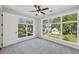 Sunlit bedroom with a large window, ceiling fan, and gray carpet flooring, offering natural light and neighborhood views at , Atlanta, GA 30310