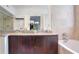 Elegant bathroom featuring dual sinks, granite countertops, and a luxurious soaking tub at 200 Renaissance Ne Pkwy # 219, Atlanta, GA 30308
