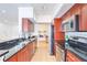 Modern kitchen with black countertops, stainless steel appliances, and sleek cherry wood cabinetry at 200 Renaissance Ne Pkwy # 219, Atlanta, GA 30308