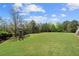Large grassy backyard features mature trees, playset and fenced perimeter at 2032 Grovewood Ct, Cumming, GA 30041