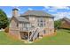 Expansive home exterior showcasing a deck, patio, and lush backyard at 2032 Grovewood Ct, Cumming, GA 30041