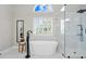 Bathroom features a soaking tub and glass shower with white marble walls and black fixtures at 2032 Grovewood Ct, Cumming, GA 30041