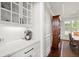 Chic butler's pantry with glass cabinets, white countertops, and beverage station near the dining area at 2032 Grovewood Ct, Cumming, GA 30041