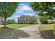 Well-maintained brick home with a spacious front yard and a long driveway, framed by mature trees at 2032 Grovewood Ct, Cumming, GA 30041