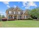 Traditional brick home with a covered porch, manicured landscaping, and symmetrical design at 2032 Grovewood Ct, Cumming, GA 30041