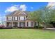Charming brick home featuring a manicured lawn, mature landscaping, and inviting curb appeal at 2032 Grovewood Ct, Cumming, GA 30041