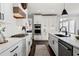 Modern kitchen with white cabinets, stainless steel appliances, and a center island, perfect for cooking at 2032 Grovewood Ct, Cumming, GA 30041