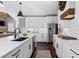 Stylish kitchen boasts white cabinetry, stainless steel appliances, a center island, and modern pendant lights at 2032 Grovewood Ct, Cumming, GA 30041
