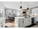 Open concept kitchen flowing to the dining room, featuring white cabinets, stainless appliances, and a center island at 2032 Grovewood Ct, Cumming, GA 30041