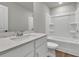 A bathroom with white cabinetry, a modern countertop, and a shower-tub combo at 2413 Malster Ln, Lawrenceville, GA 30043