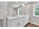 Bright bathroom featuring double vanity with granite countertop and large mirror, and a window at 2413 Malster Ln, Lawrenceville, GA 30043