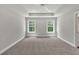 A primary bedroom featuring neutral carpet, two windows, recessed lighting, and tray ceiling at 2413 Malster Ln, Lawrenceville, GA 30043